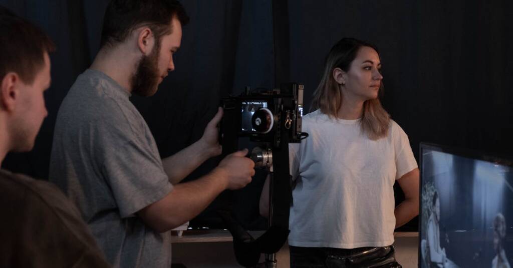A diverse team collaborates in a studio, setting up a video recording with professional equipment.